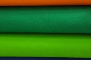 Sklep włókienniczy materiał różne kolory różowy pomarańczowy zielony niebieski